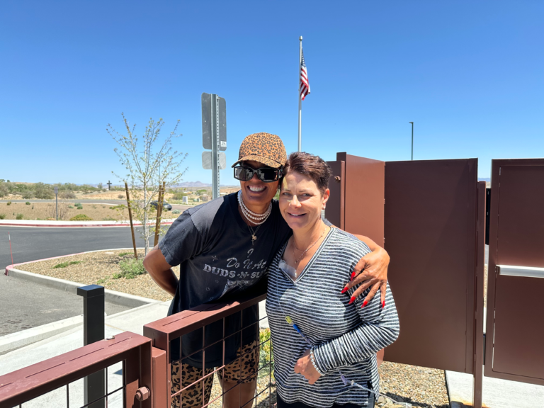 Woman during chemotherapy treatment standing outdoors with childhood friend during treatment