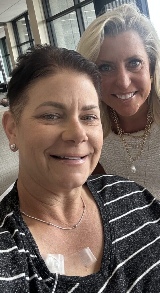 Sitting in a chemotherapy treatment chair during cancer treatment with a support person nearby