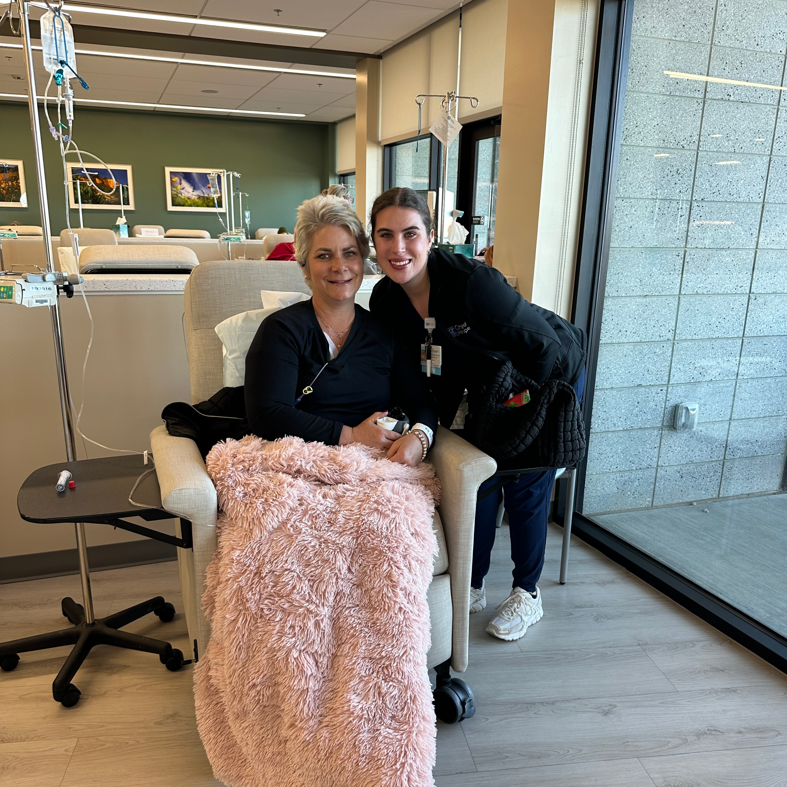 Woman receiving chemotherapy treatment with supportive nurse during cancer journey