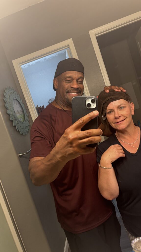 Woman seeing herself in mirror for the first time after her boyfriend shaved her head from hair loss